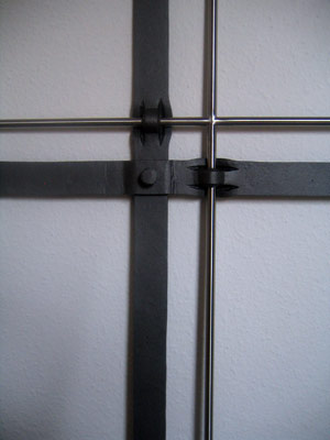 Kreuz mit schmalerem Kreuz aus runden Metallstäben verbunden in Detailansicht